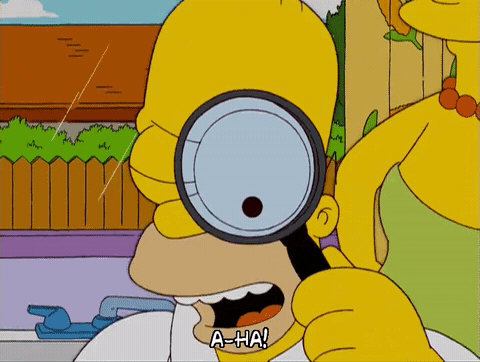 Homer Simpson privește printr-o lupă și exclamă A-HA!